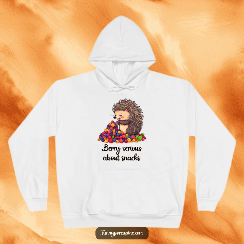 Funny hoodie with an enthusiastic porcupine happily shoveling a massive pile of colorful berries, offering warmth and humorous charm.